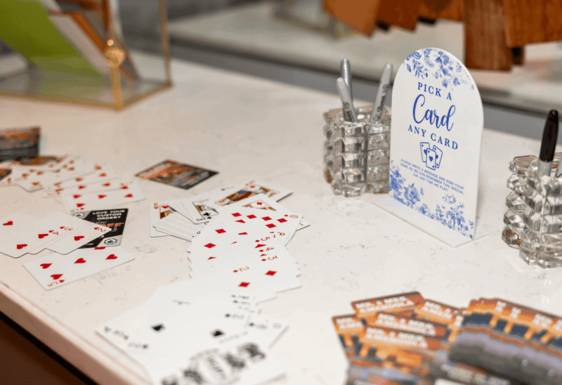 Playing cards on a table with a card selection guide and decorative items.