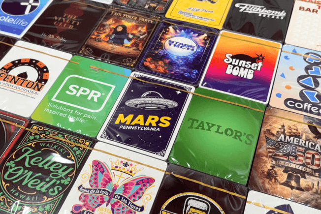 Collection of various branded coasters with different designs and text.
